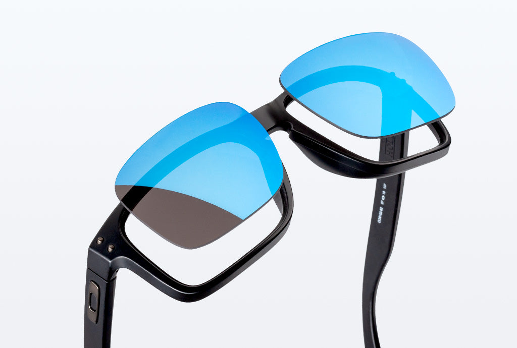 A pair of blue lenses floating above black frames against a white backdrop.
