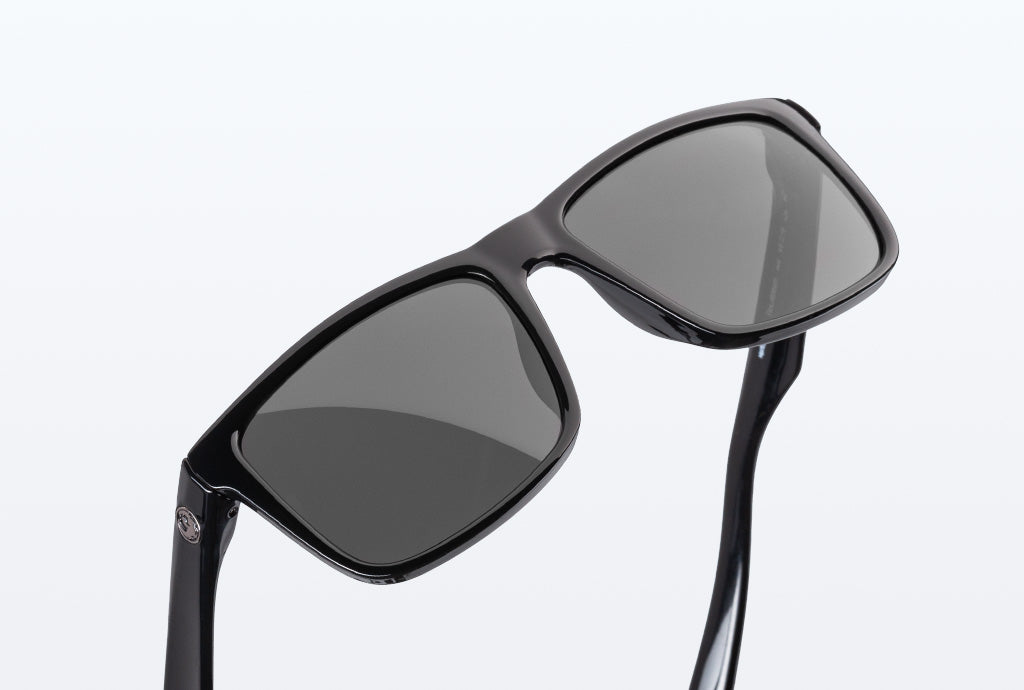 A pair of black frames with black lenses against a white backdrop.